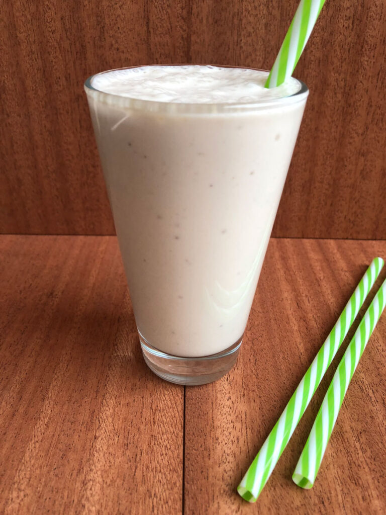Healthy chai milkshake in a glass with straw.