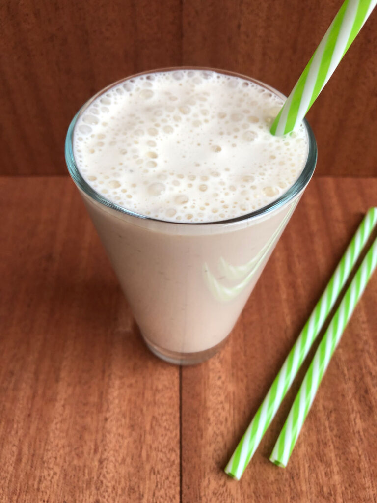 Healthy chai milkshake in a glass with straw.