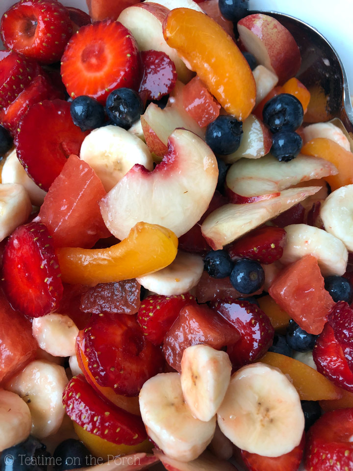 Colorful summer fruit salad with blueberries, strawberries, nectarines, apricots, watermelon, and banana, served in a bowl.