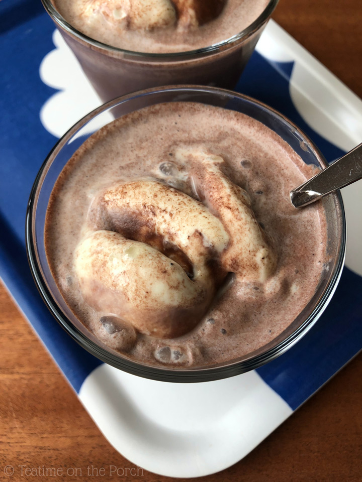 Classic German Iced Chocolate German iced chocolate, chilled hot chocolate with vanilla ice cream, served in a glass with a spoon, in top view.
