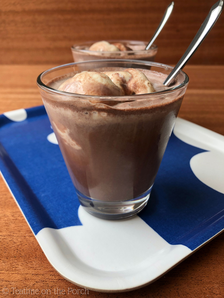 German Iced Chocolate Recipe German iced chocolate, chilled hot chocolate with vanilla ice cream, served in a glass with a spoon, with another serving in the background.