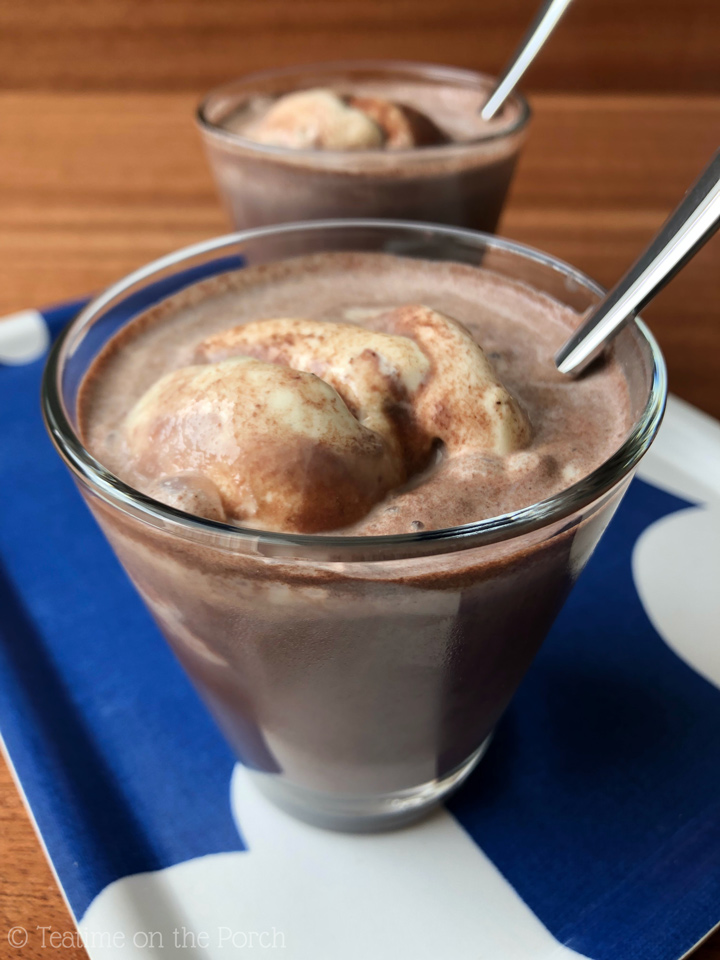 German Iced Chocolate German iced chocolate, chilled hot chocolate with vanilla ice cream, served in a glass with a spoon, with another serving in the background.