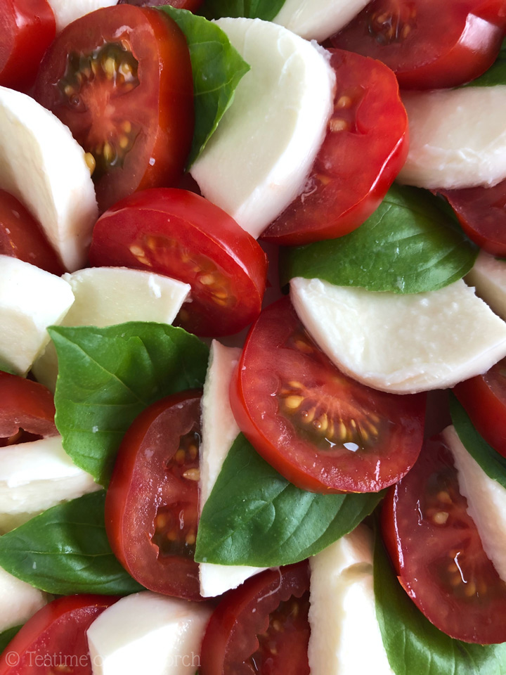 How to Make Caprese Salad Sliced tomatoes, fresh mozzarella, and fresh basil leaves arranged to make a caprese salad.