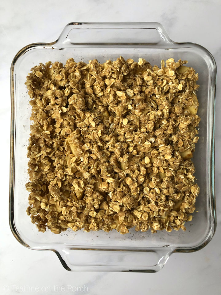 How to Make Healthy Apple Crisp 8-inch square glass baking dish with healthy apple crisp, ready to be baked.