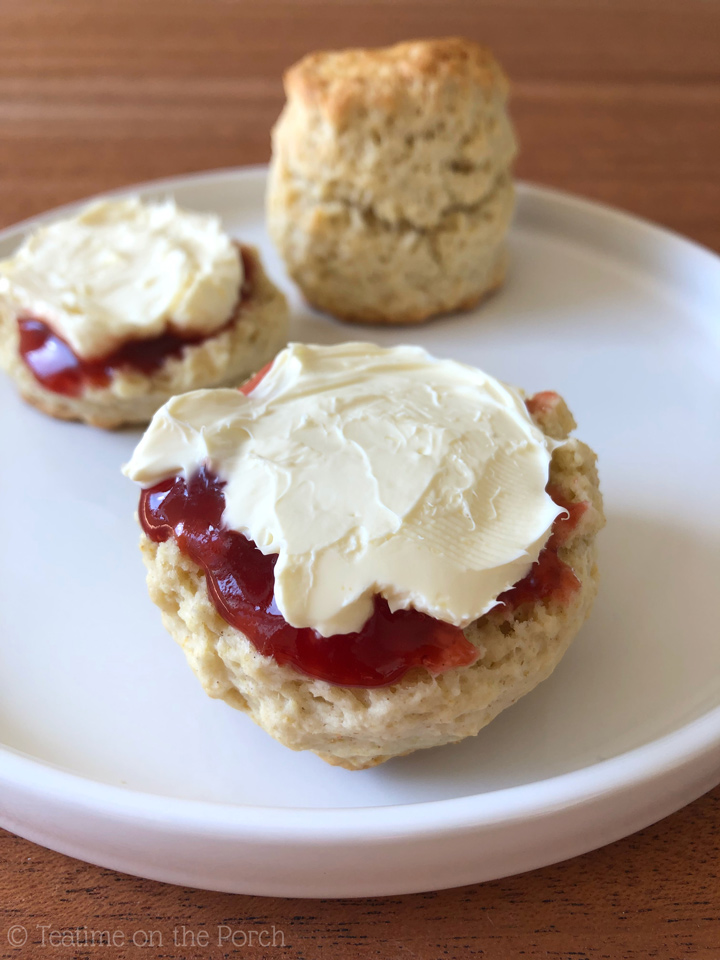 Classic British Scones Classic British scones on a plate served with strawberry jam and clotted cream.