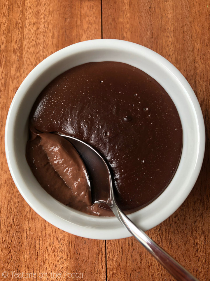 Homemade Chocolate Pudding Homemade chocolate pudding served in a white ramekin with a spoon.