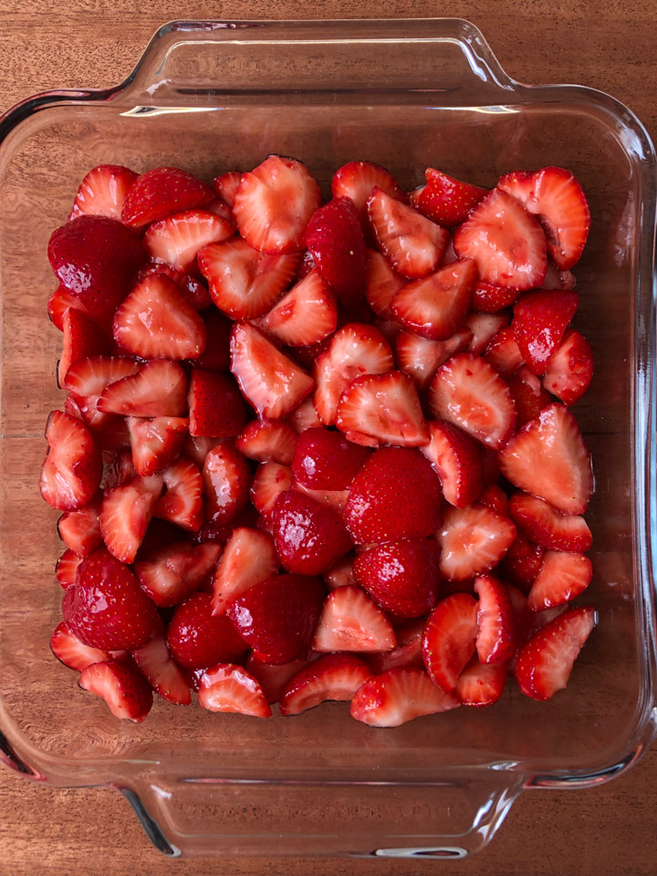 How to Make Healthy Strawberry Crisp Quartered strawberries, tossed with sweetener, in an 8-inch square pan.